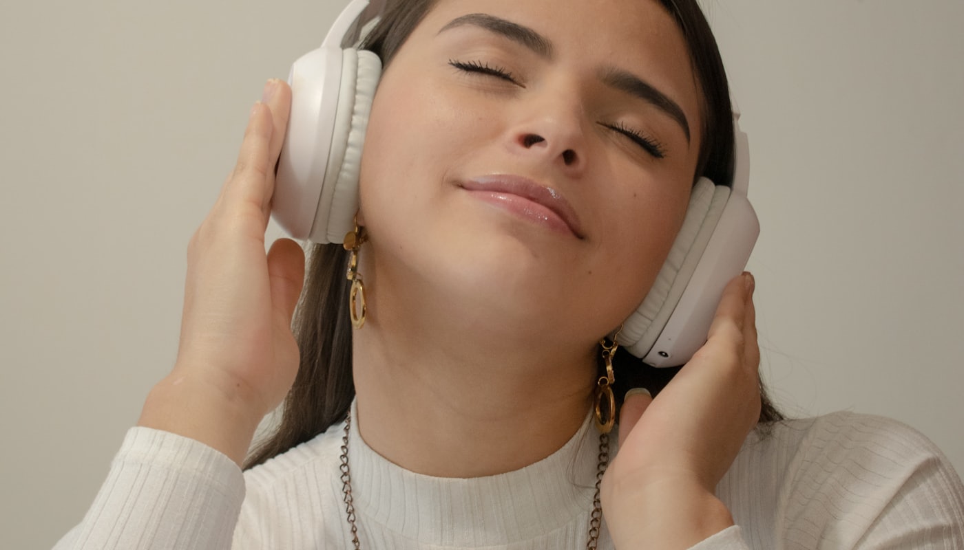 A person with eyes closed speaking on a phone