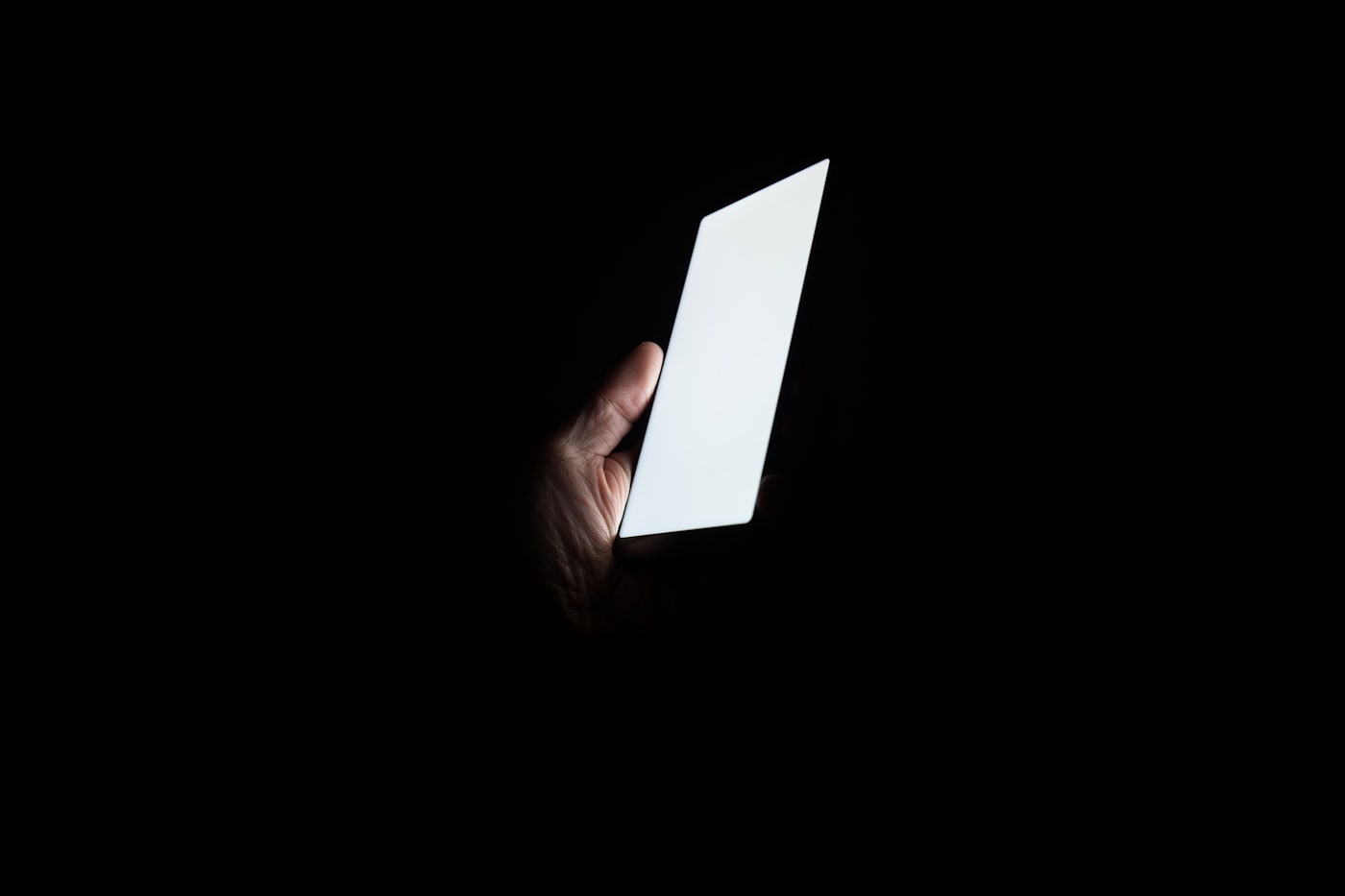A glowing phone screen in a dark room at night