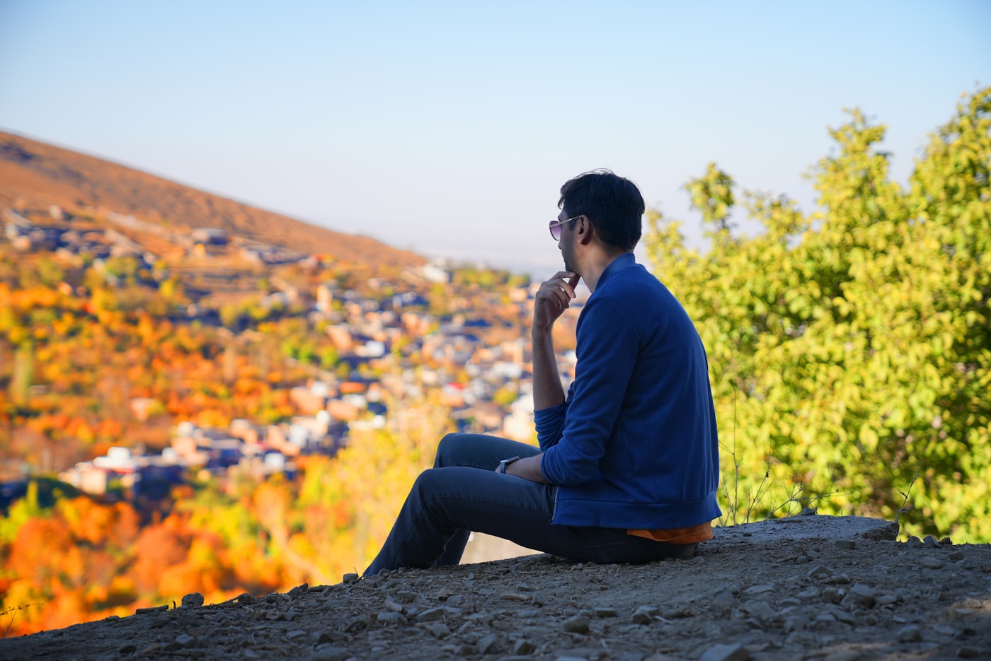 A person sitting outdoors on a phone call
