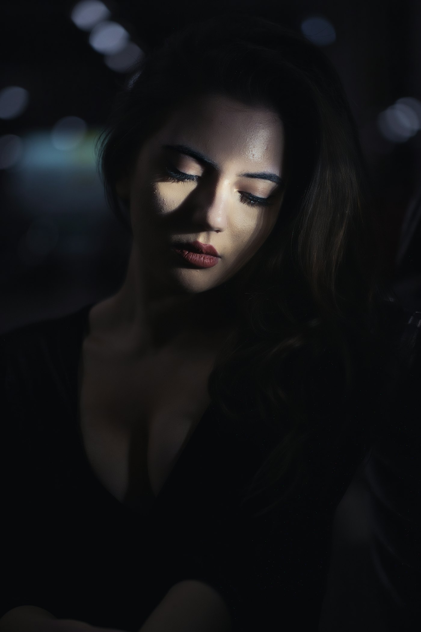 A person alone in a dark room looking at a phone