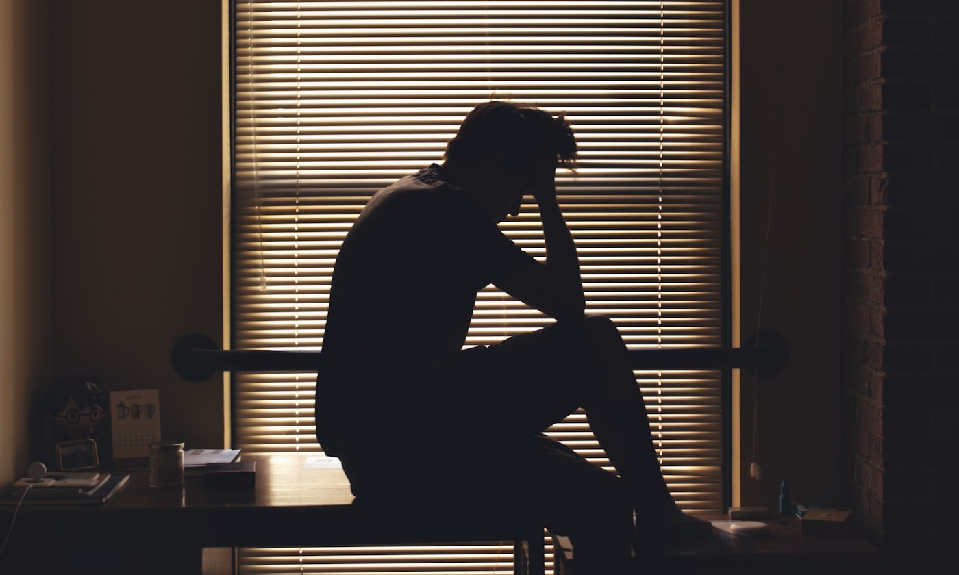 Silhouetted person sitting alone